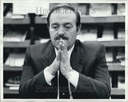 Press Photo A Man In A Suit Presses His Hands Together And Thinks - Historic Images