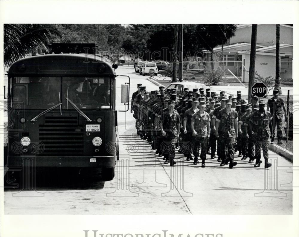 Press Photo Marines march past a bus full of newly arrived Cuban refugees - Historic Images