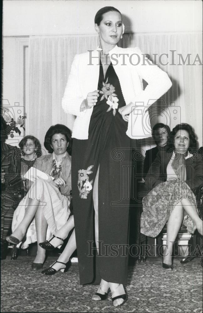 Press Photo Model Poses In Black Flowered Wrap Dress And Coat In Greece - Historic Images