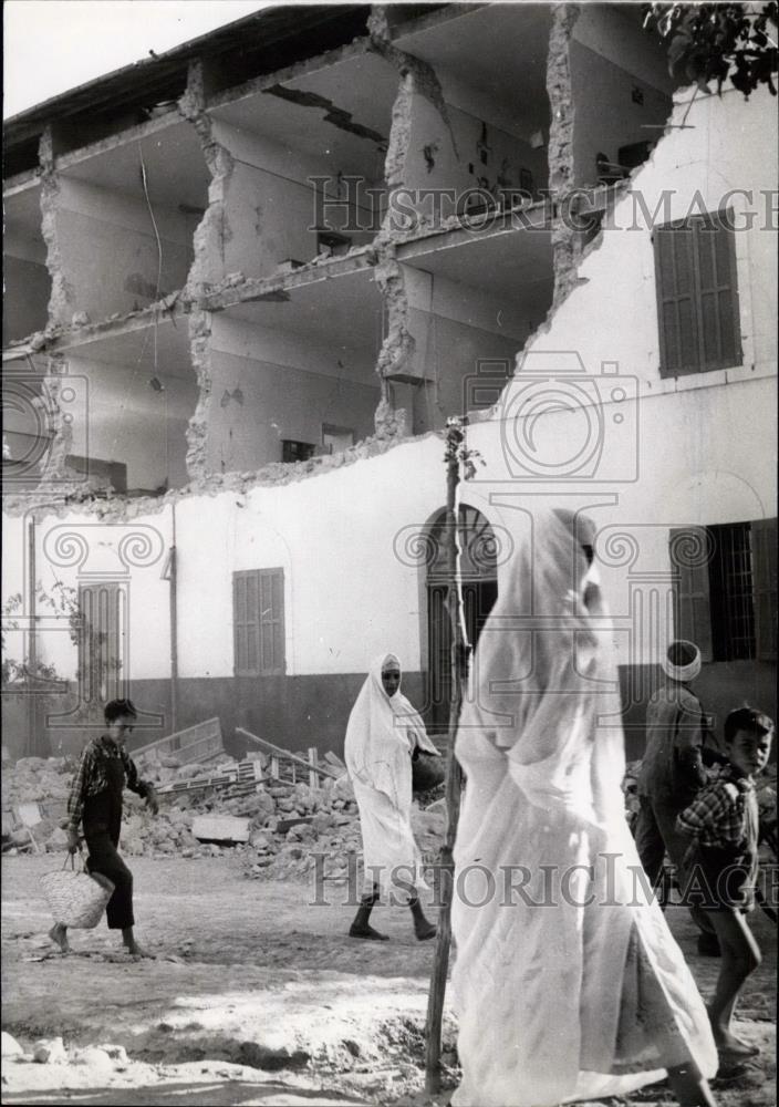 Press Photo Children and veiled woman pass before the wreckage of an apartment h - Historic Images