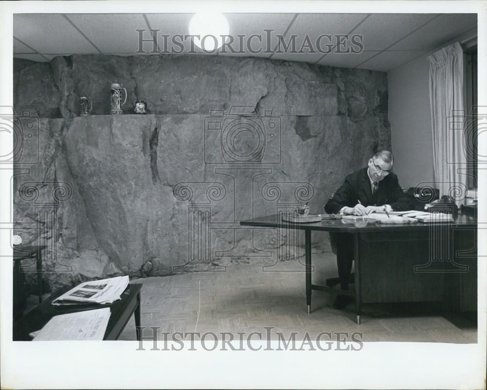 Press Photo A Man At His Desk In A Cave-Like Building - Historic Images