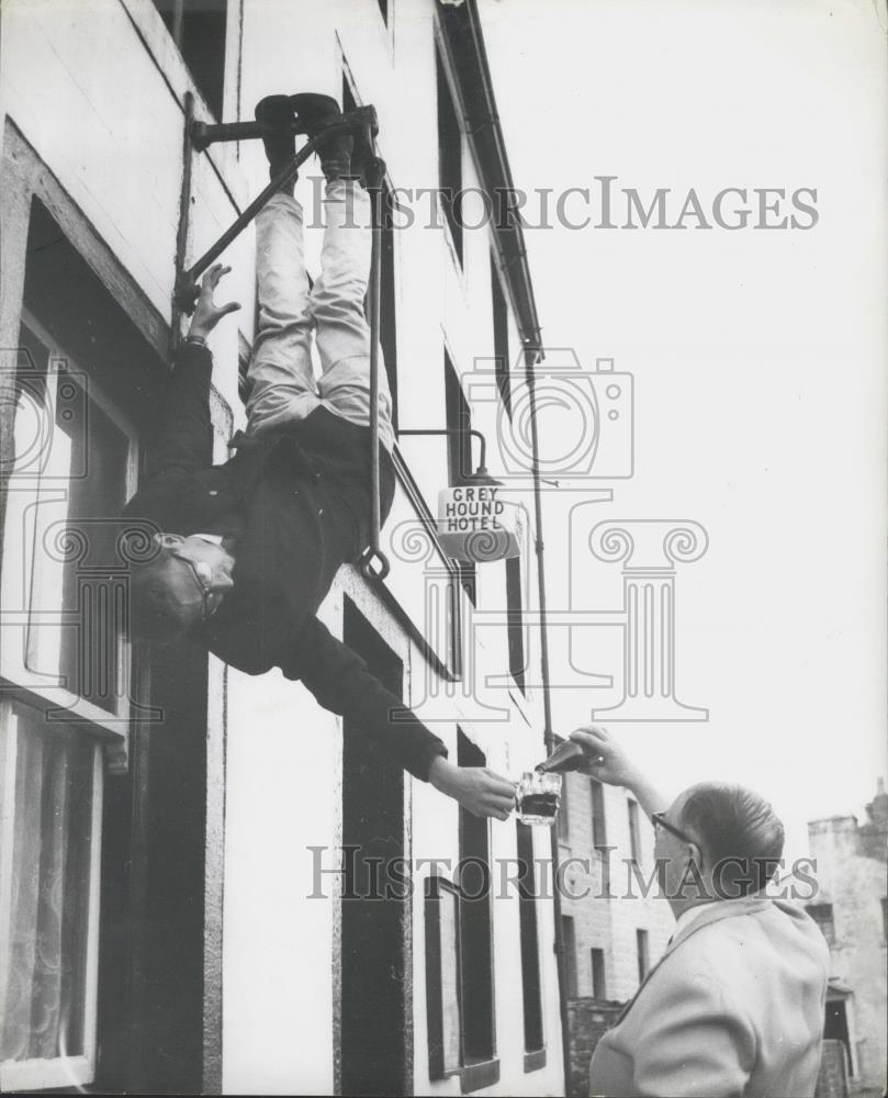 Press Photo Terry Andrews just hanging around upside down outside his bar - Historic Images