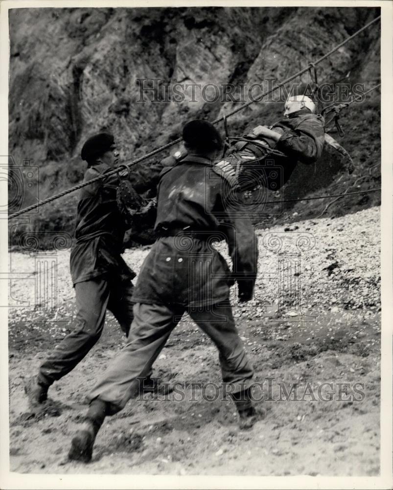 1955 Press Photo A man in a Neil Robinson Stretcher is lowered down cliff side - Historic Images