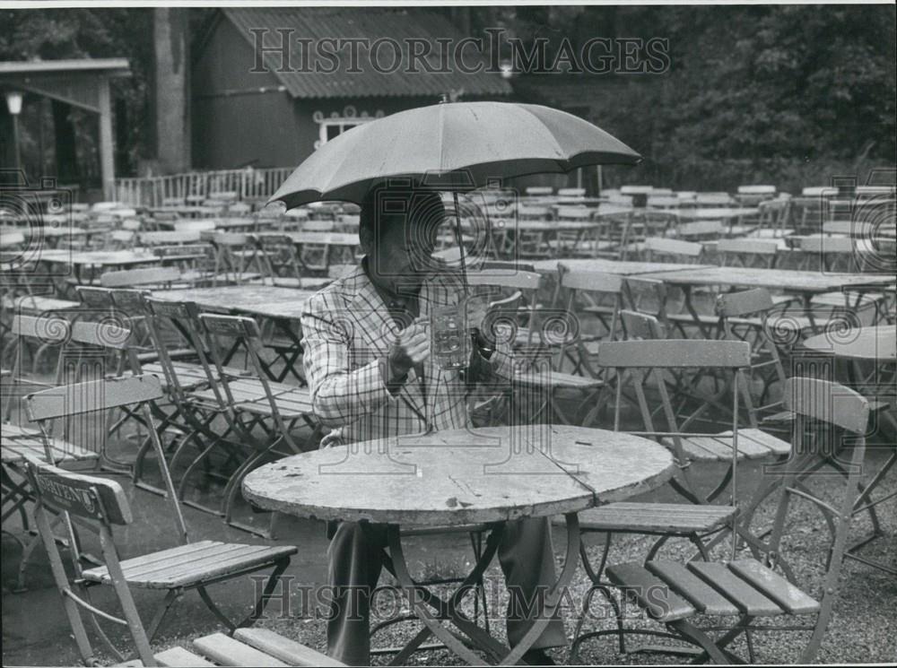 Press Photo Bavarian Settled In Empty Beer Garden During Rainfall In Munich - Historic Images