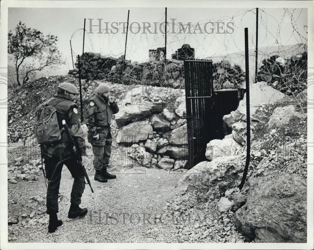 Press Photo Two Soldiers Wait With Their Weapons Near Barbed Wire - Historic Images