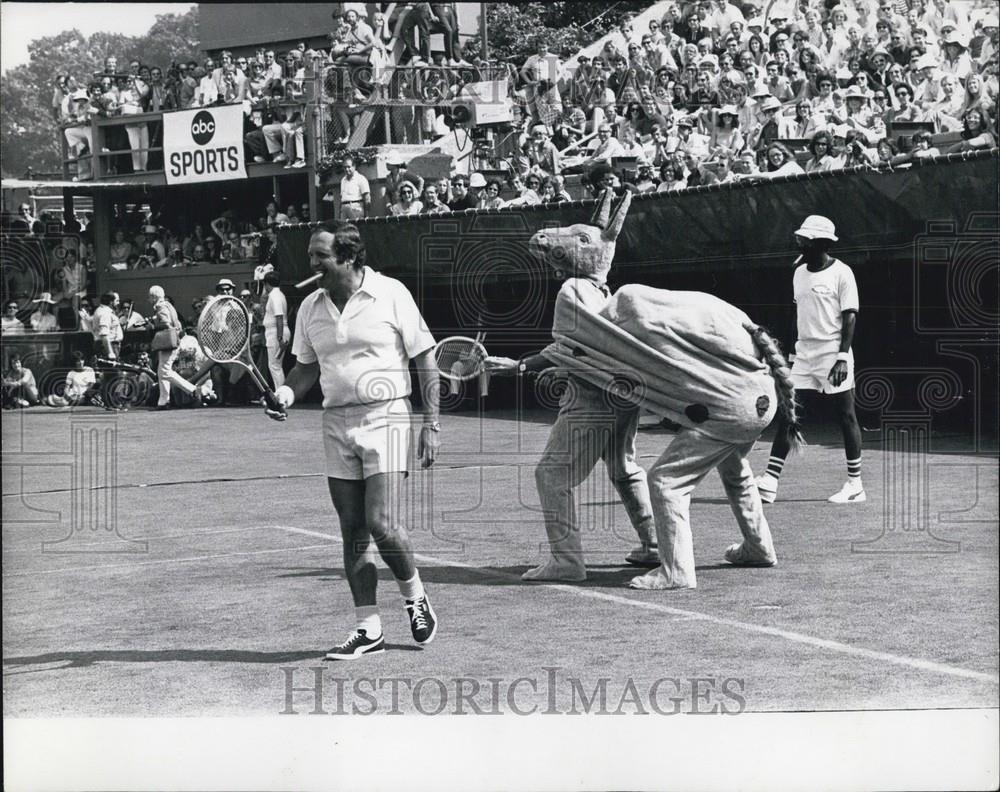 Press Photo Allan King Plays Tennis With A Donkey Mascot Behind Him - Historic Images