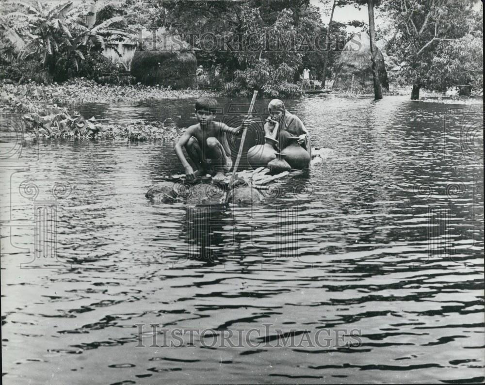 1974 Press Photo Two Young Esters on Banana plant raft in flood In Kishorganj - Historic Images