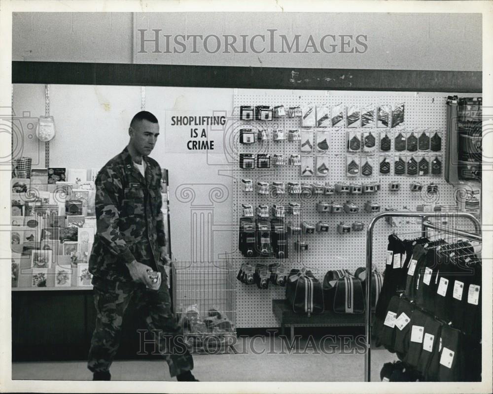 Press Photo An Officer In Camouflage Walks In A Store - Historic Images