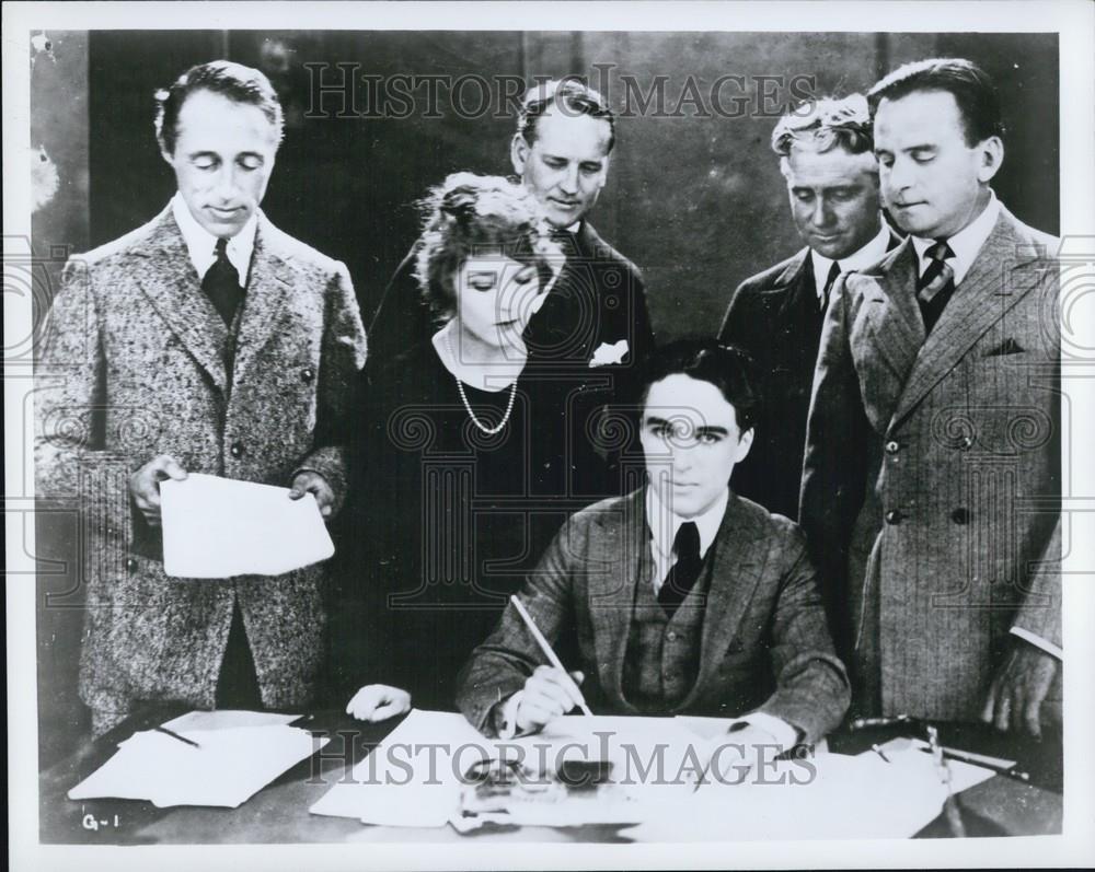 Press Photo A Group Watches As A Man Signs A Document - Historic Images