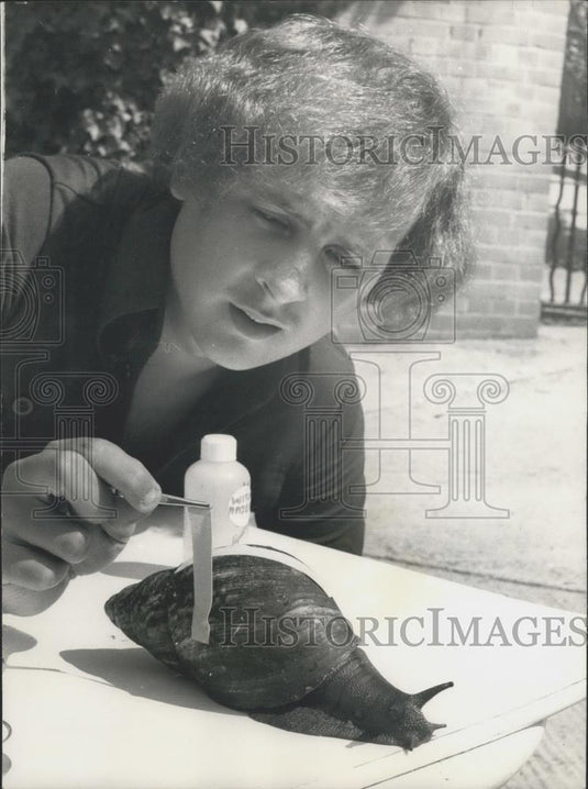 Press Photo Chris Hudson measuring a huge snail found in W. Africa - Historic Images