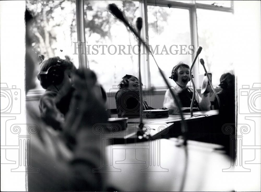 Press Photo Children listen to music on headphones as they play - Historic Images