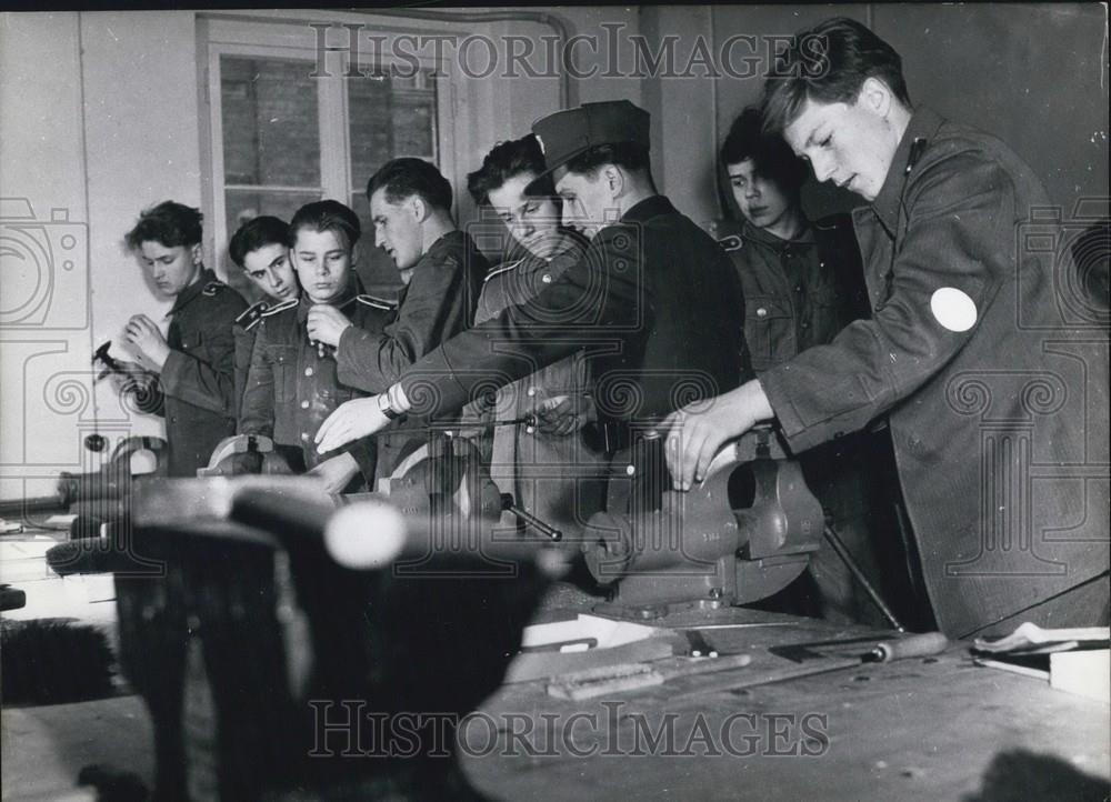 Press Photo Young Men In Uniforms Work With Clamps - Historic Images