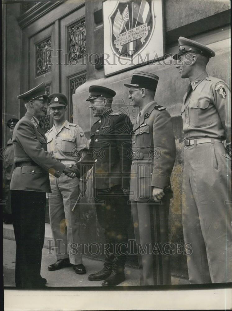 Press Photo Officers Shake Hands Beside International Patrol Sign - Historic Images