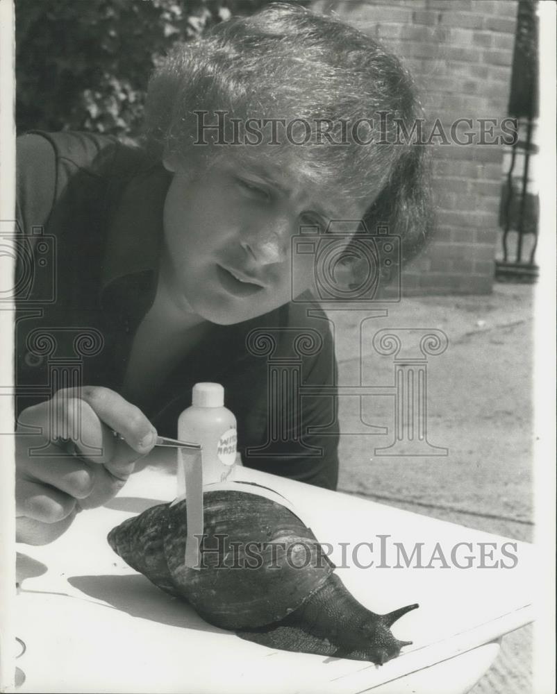 Press Photo Chris Hudson with a monster size snail from W. Africa - Historic Images