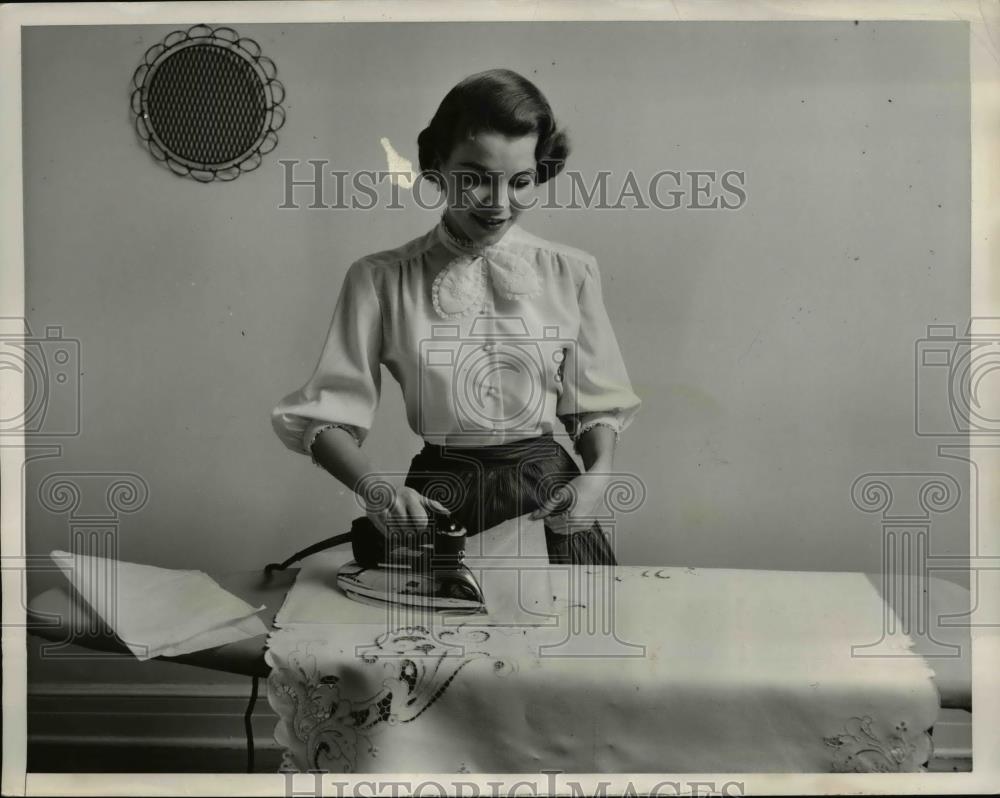 1956 Press Photo Homemaker using an iron on embroidered fabric - Historic Images