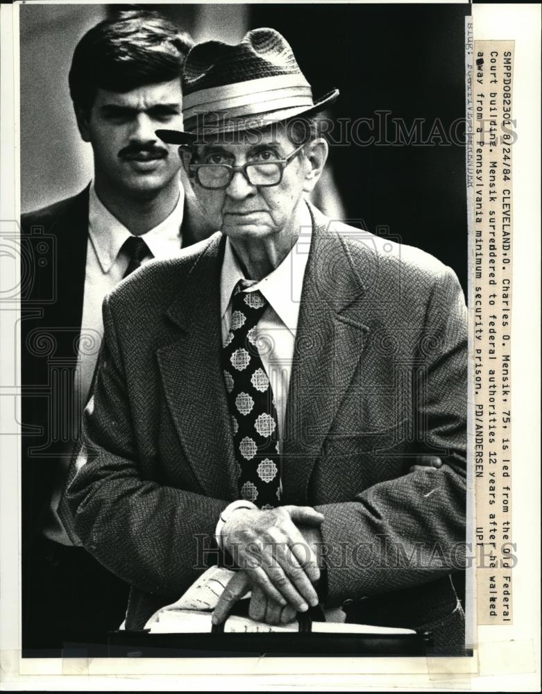 1984 Press Photo Charles O. Mensik is led from the Old Federal Court Building - Historic Images