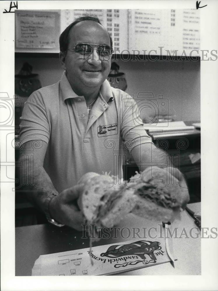 1983 Press Photo Joe Loree with two halves of sub sandwiches at his Store - Historic Images