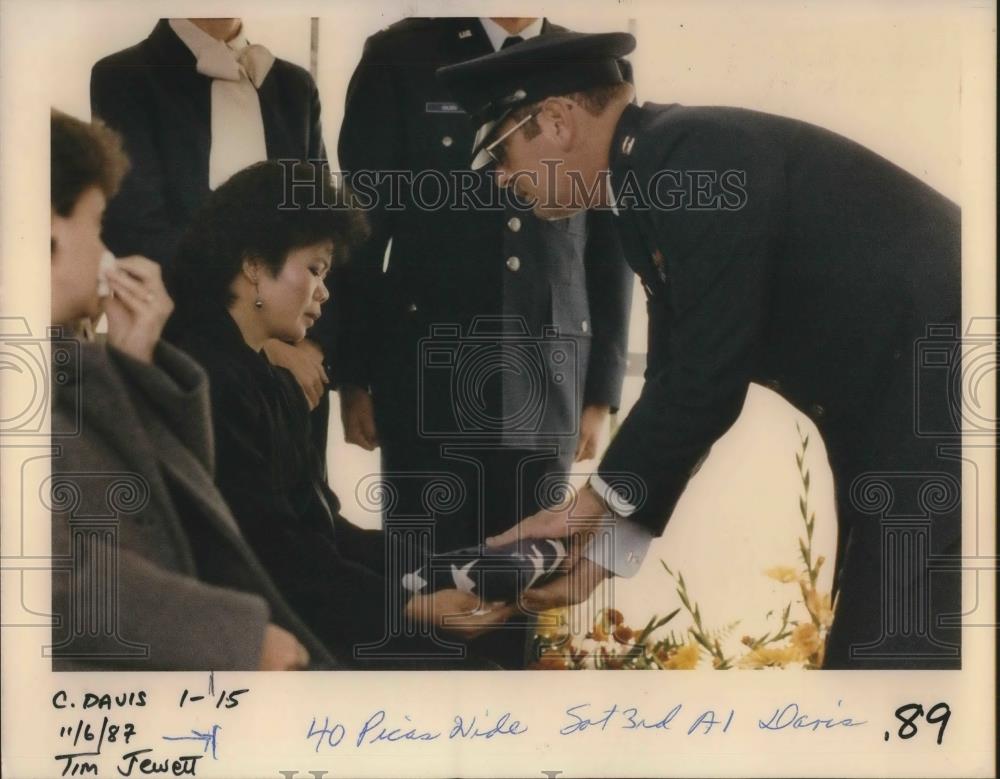 1987 Press Photo Lourdes Davis given flag from coffin of husband by Capt. Maddox - Historic Images