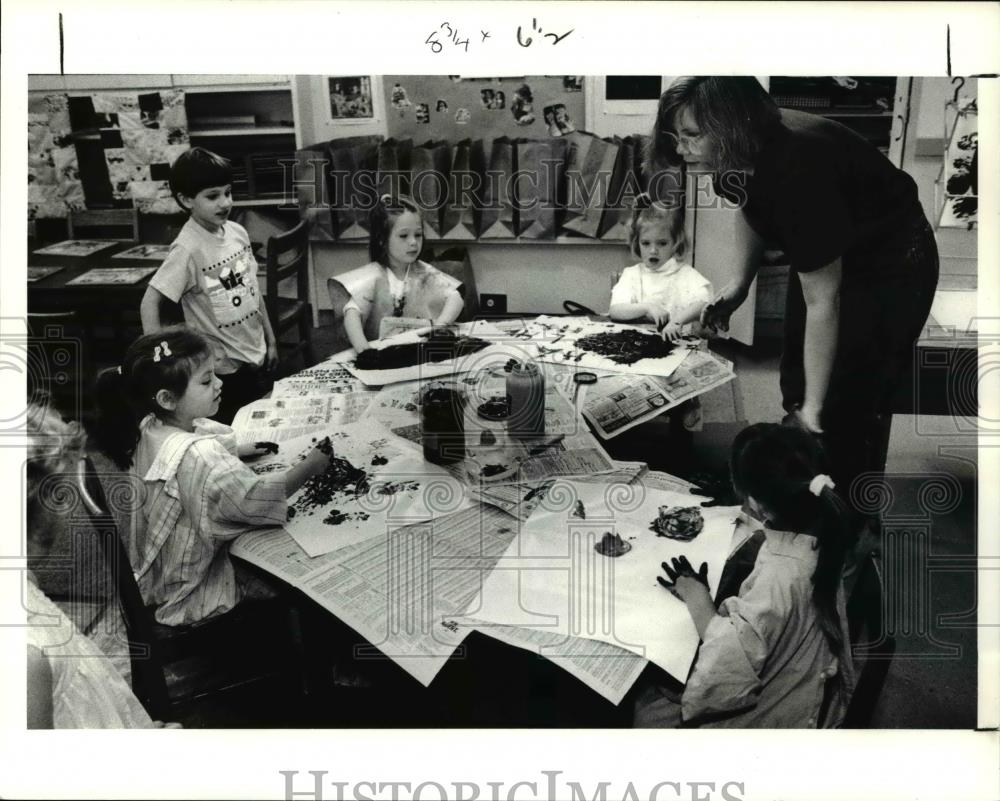 1991 Press Photo Barb Mc Cue, showing the children how to finger paint - Historic Images