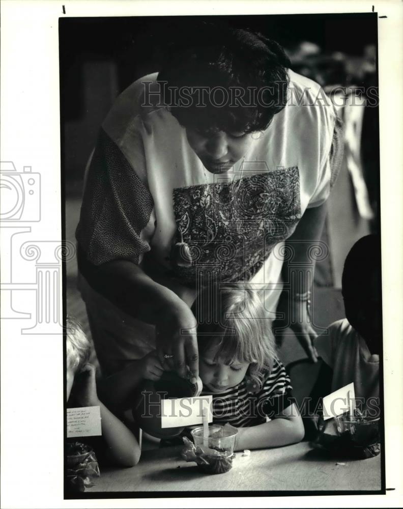 1990 Press Photo Lisa Walker helps Alexandra Marchant water the marigold - Historic Images