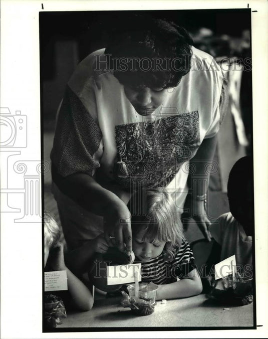1990 Press Photo Lisa Walker helps Alexandra Marchant water the marigold - Historic Images