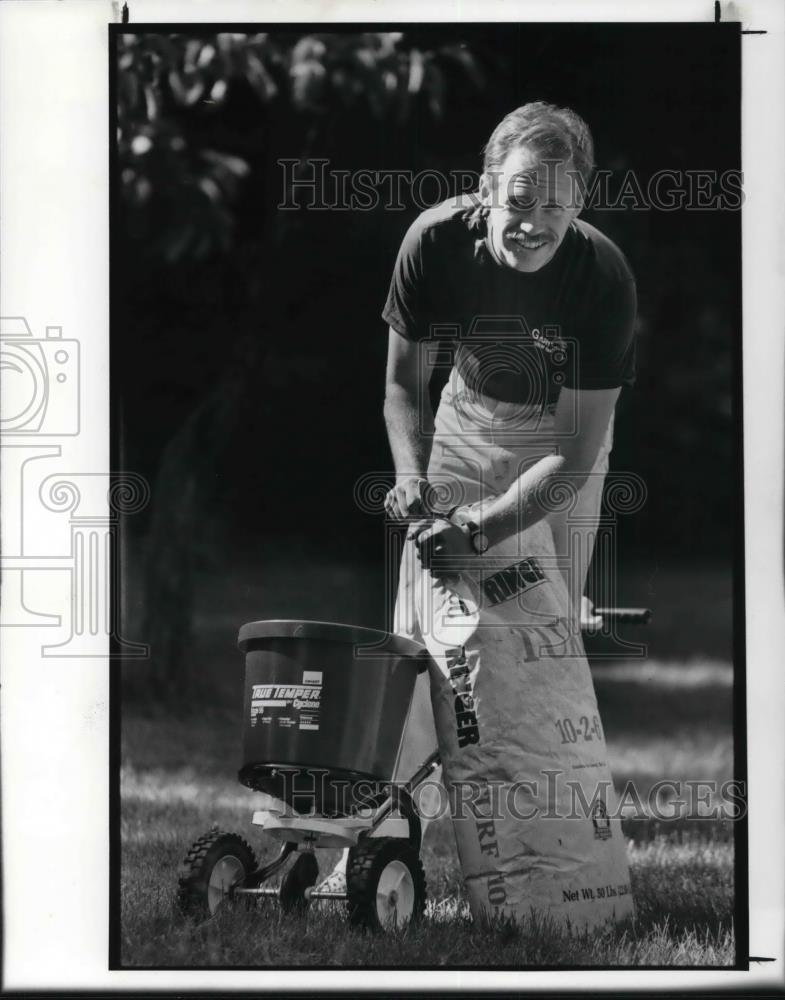 1990 Press Photo Tim Maher prepares Natural fertilizer into a spreader - Historic Images