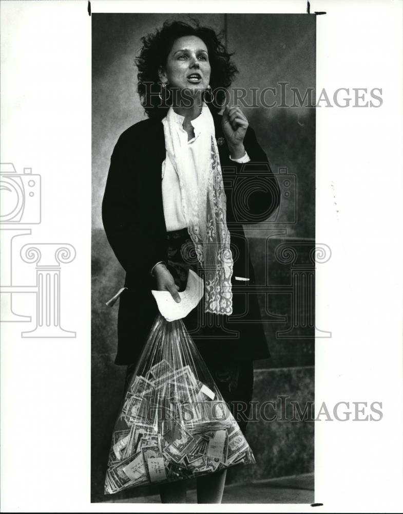 1988 Press Photo Judy T. Opalach holds a plastic bag containing $1,448.44 - Historic Images