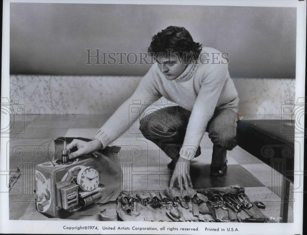1974 Press Photo Charlie Braddock examines crude bomb for Juggernaut movie - Historic Images