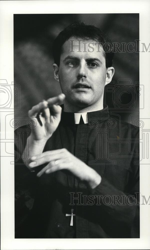 1987 Press Photo Cleveland Priest Mike Riley Signs at United Church of Christ - Historic Images