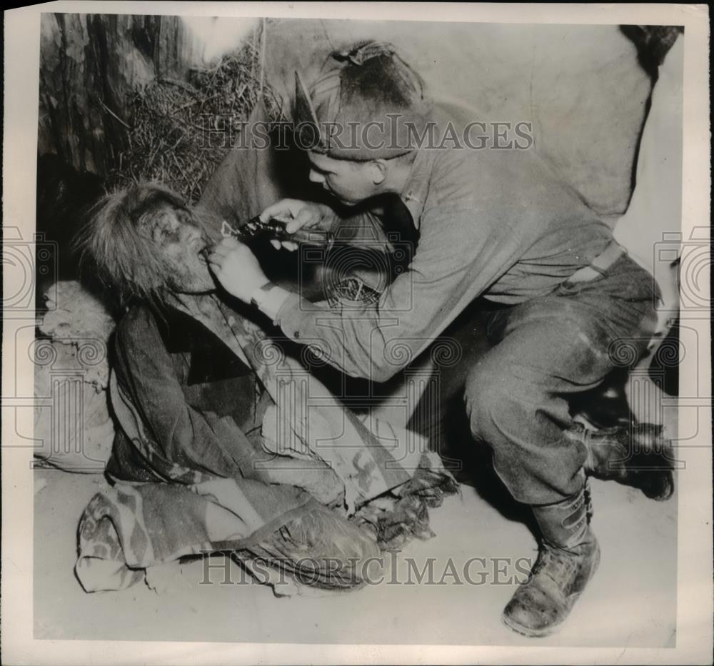 1949 Press Photo of Cpt. George W. Magladry examining a Navajo woman. - Historic Images