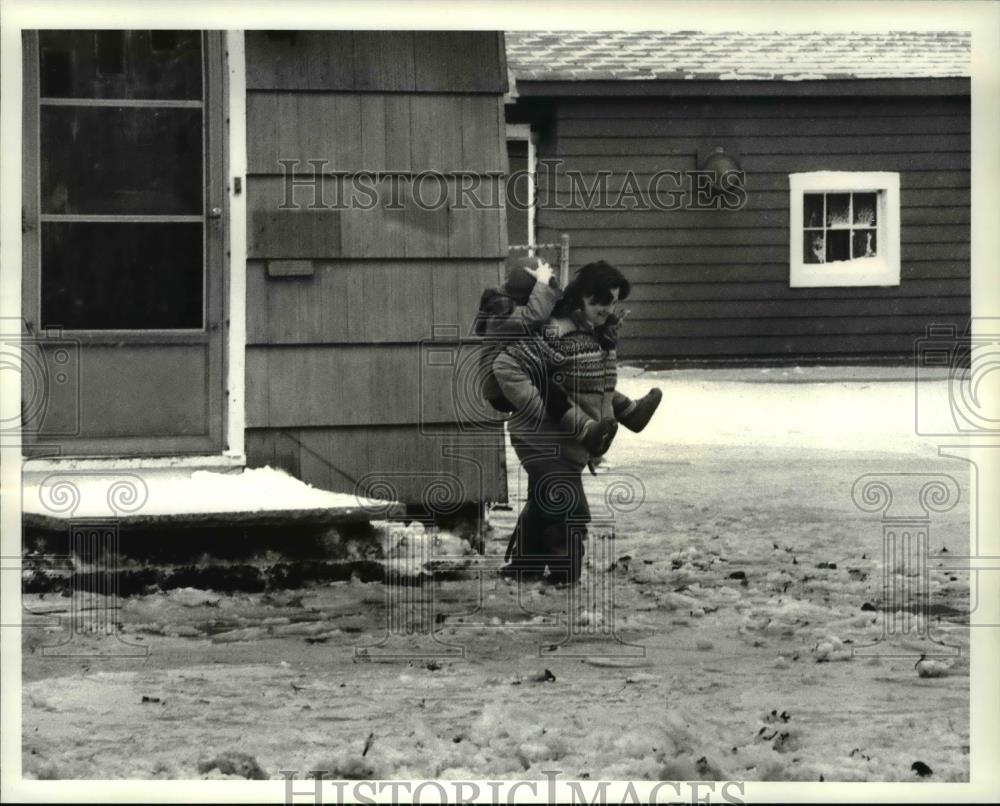 1987 Press Photo Karen Jackson carries her son, Kevin while crossing the flood - Historic Images