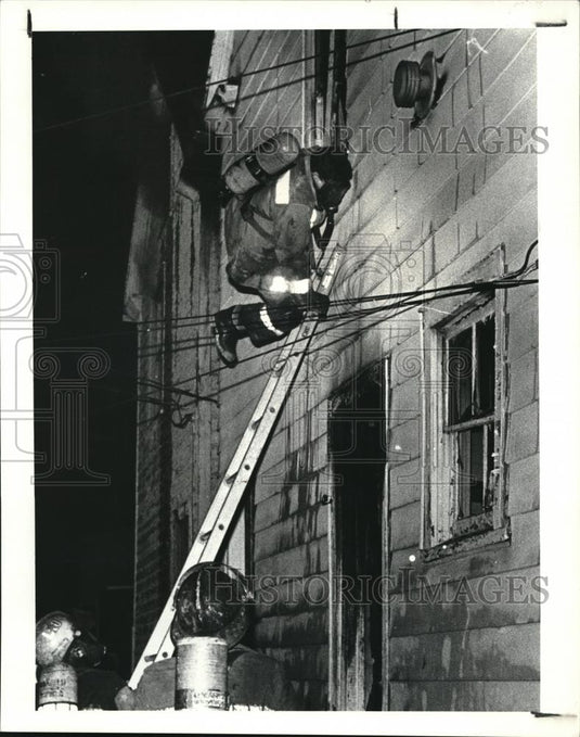 1987 Press Photo A firefighter up the ladder during the blaze - Historic Images