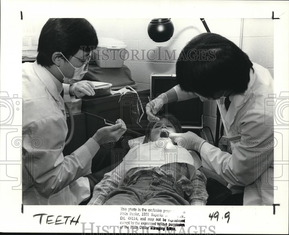 1988 Press Photo CWRU dental students as they put sealants on a kid&#39;s teeth - Historic Images