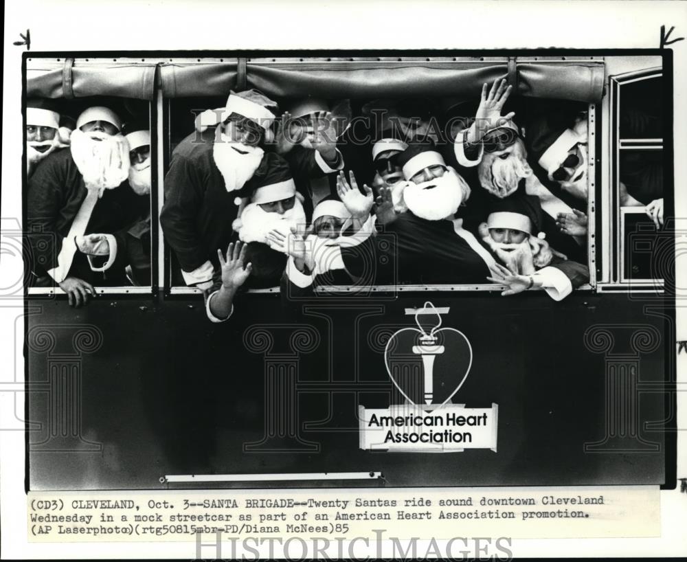 1985 Press Photo Twenty Santas ride around downtown Cleveland ina mock steetcar - Historic Images