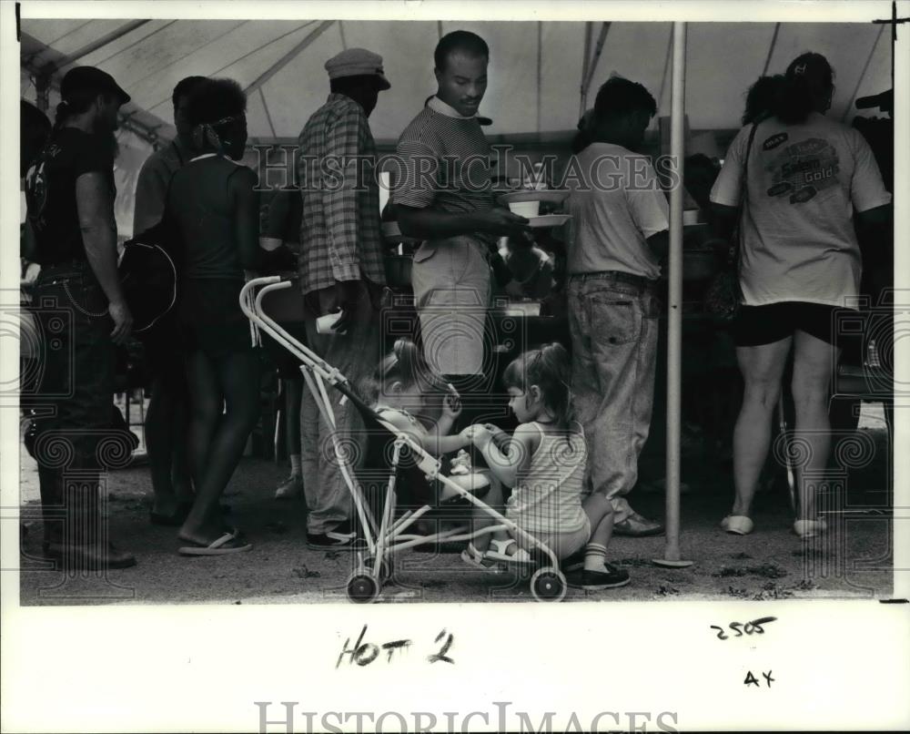 1991 Press Photo Ramon Ortiz watches his kids while he is for free turkey dinner - Historic Images
