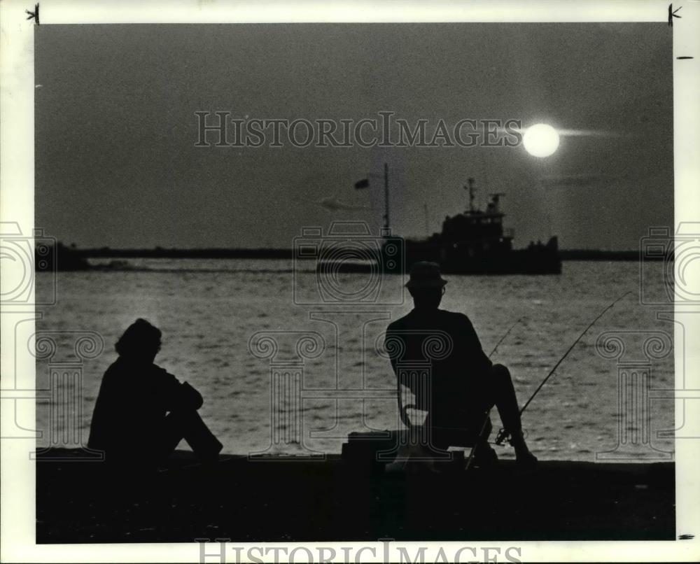 1984 Press Photo Fisherman, tug and setting sun, Pier 34 - Historic Images