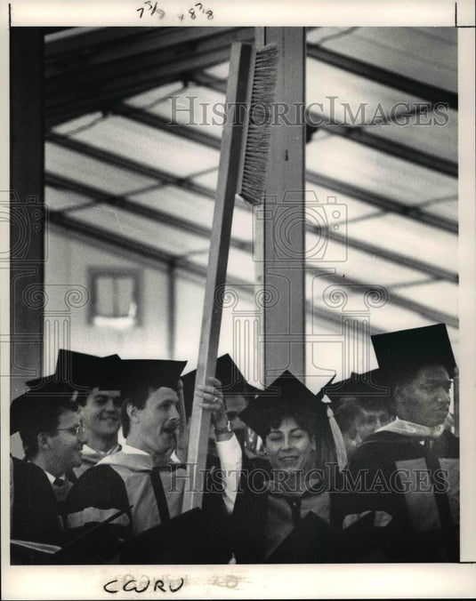1991 Press Photo Graduates of CWRU dental school waved a giant toothbrush as - Historic Images