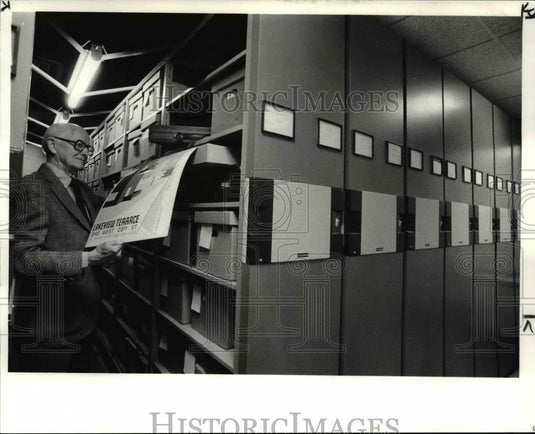 1984 Press Photo Architect of the Lakeview Terrace Apts. looks at a poster - Historic Images