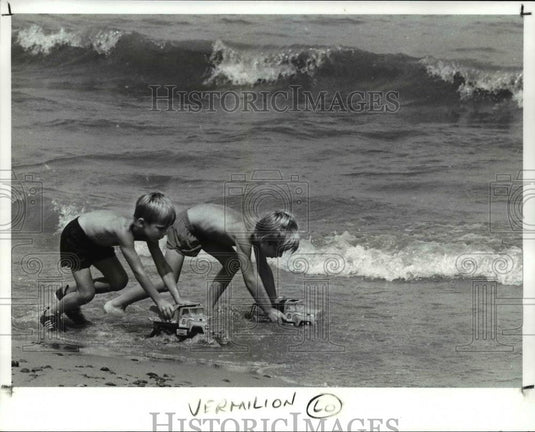 1988 Press Photo They race their toy trucks in the surf at Main Street Beach - Historic Images