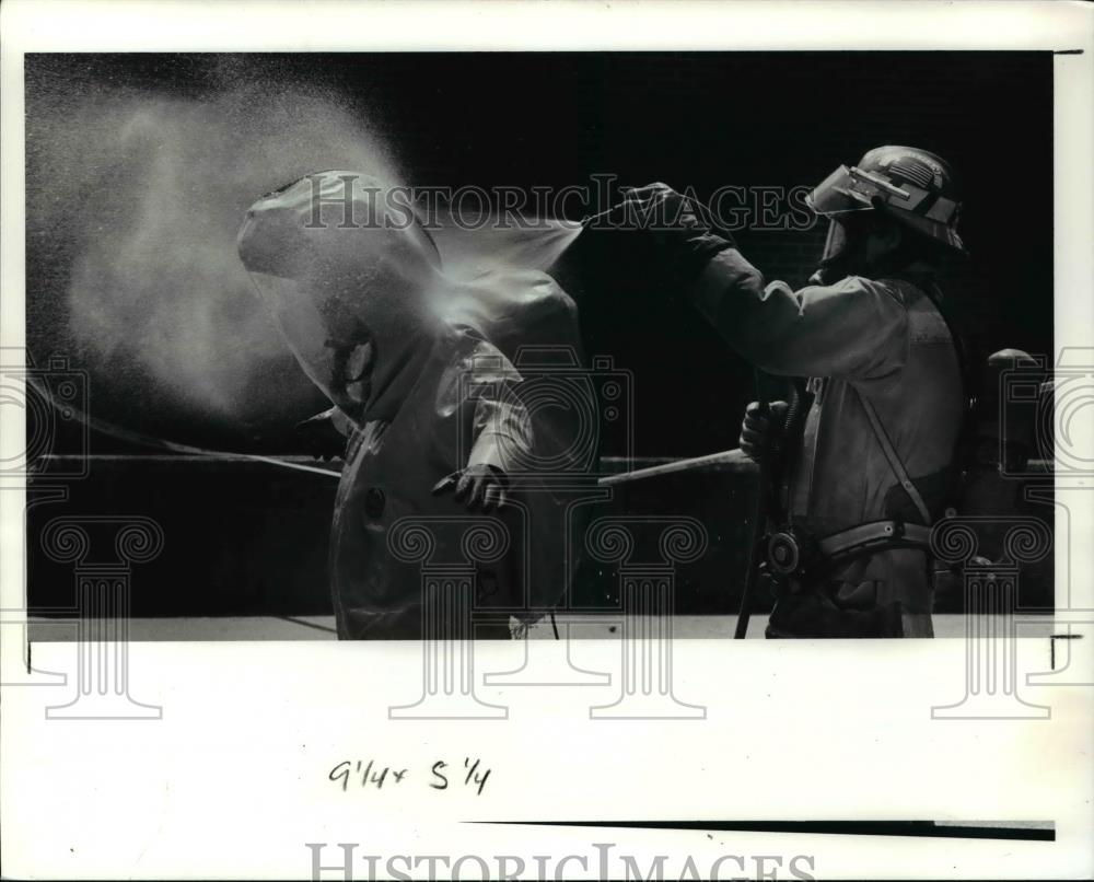 1991 Press Photo A cleveland firemean washes down a member of the - Historic Images