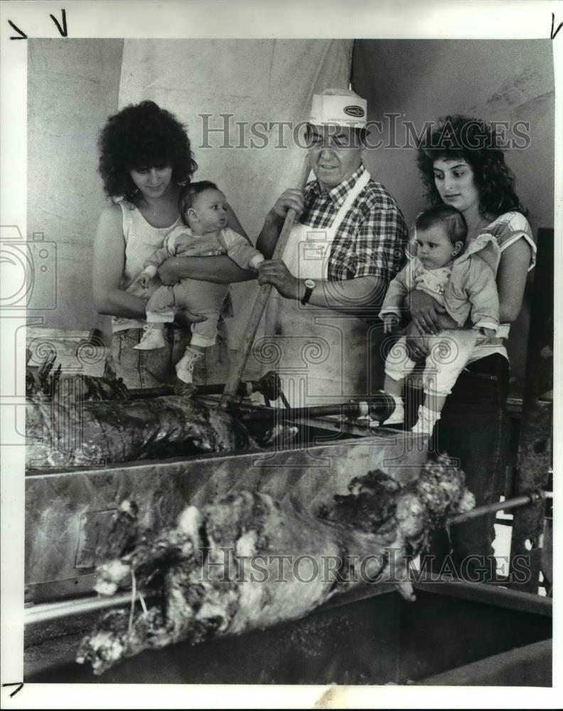 1989 Press Photo Tom Tsigas stirs coal under barbecued lamb for Greek Heritage - Historic Images