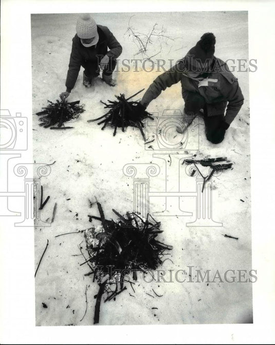 1985 Press Photo Donna Leffler & Susan Boele add wood fire during winter camping - Historic Images