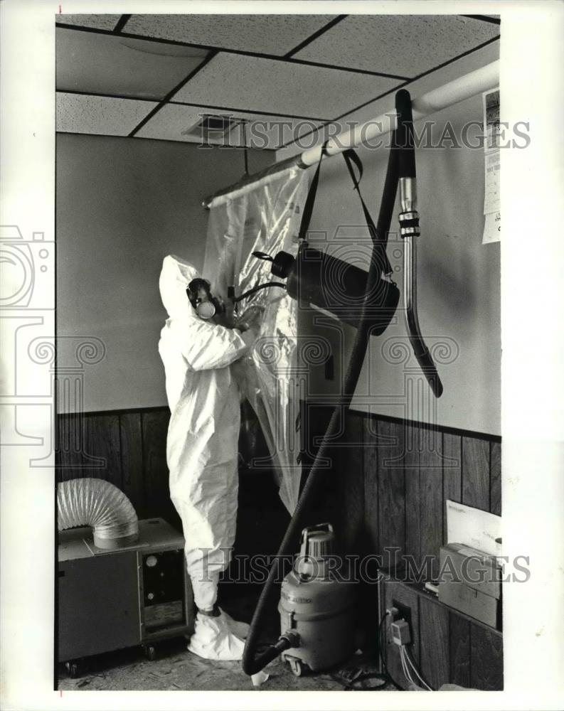 1987 Press Photo Worker in protective suit showing how asbestos is removed - Historic Images