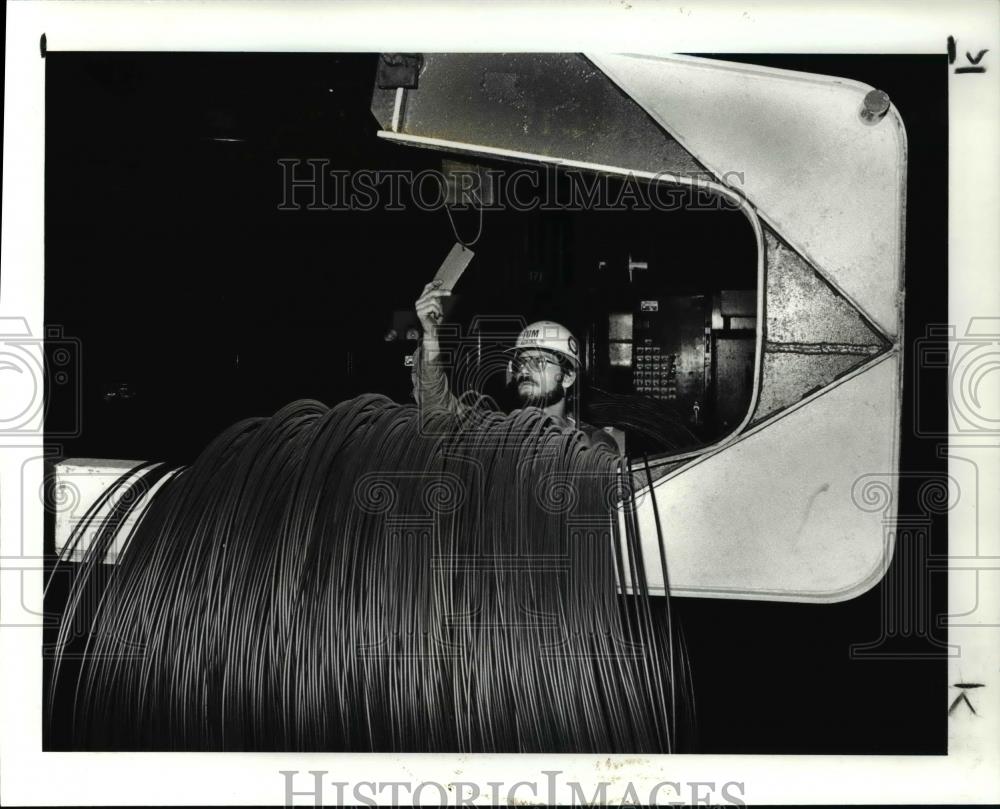 1986 Press Photo Tom Adkins Checks A Coil Wire Going To Banding Machine - Historic Images