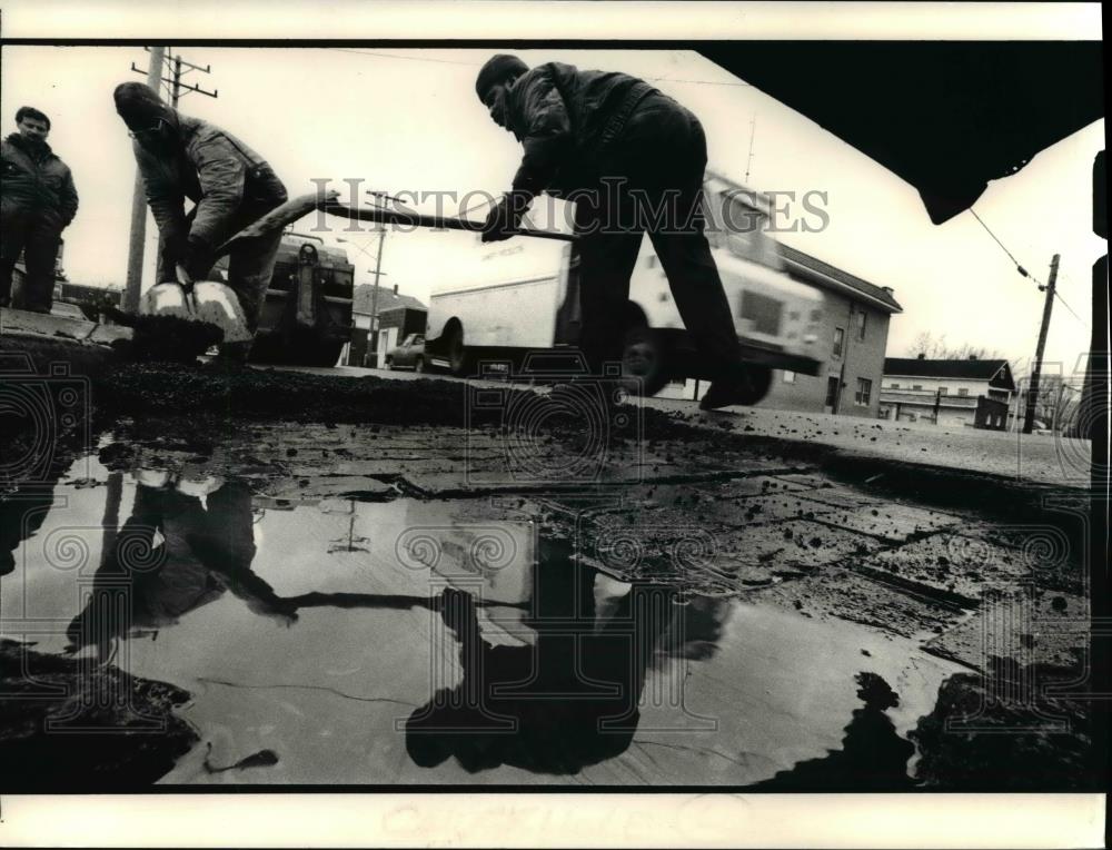 1990 Press Photo Joe Nelson and Robert Giles repair the chuckhole - Historic Images