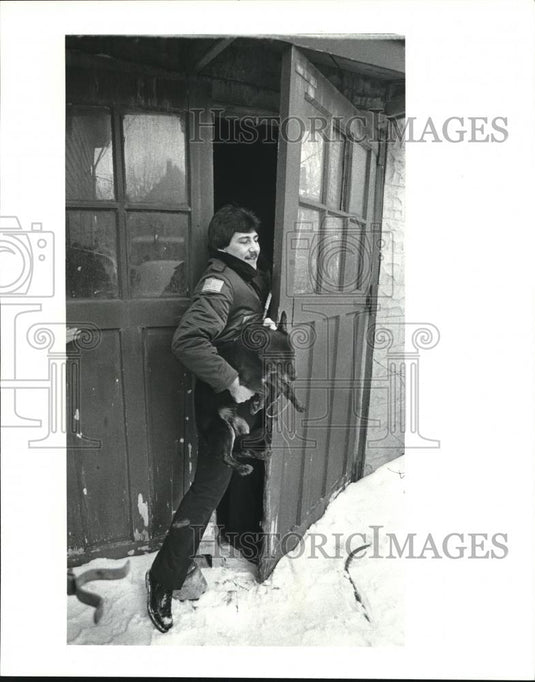 1984 Press Photo APL officers carrying a dog who was taken from the resident - Historic Images