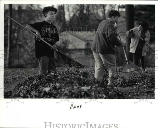 1991 Press Photo Bedford School Teacher rake the yard of Mrs. Kathleen Corrigan - Historic Images