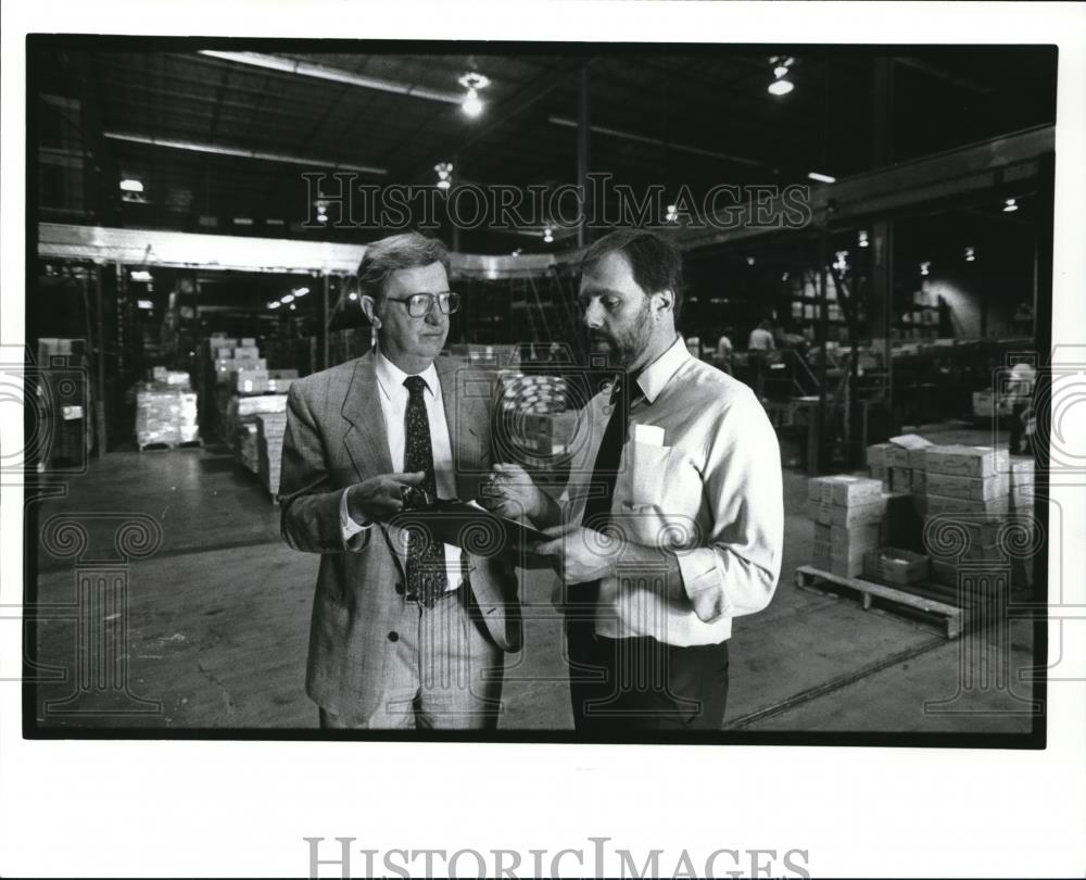 1989 Press Photo Ray Presendergast talks with his warehouse manager - Historic Images