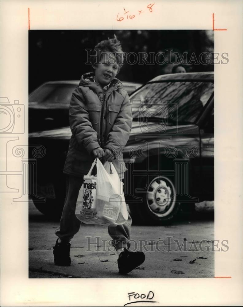 1991 Press Photo Andy Christiansen, 7 of Cub Scout Pack delivers a bag of food - Historic Images