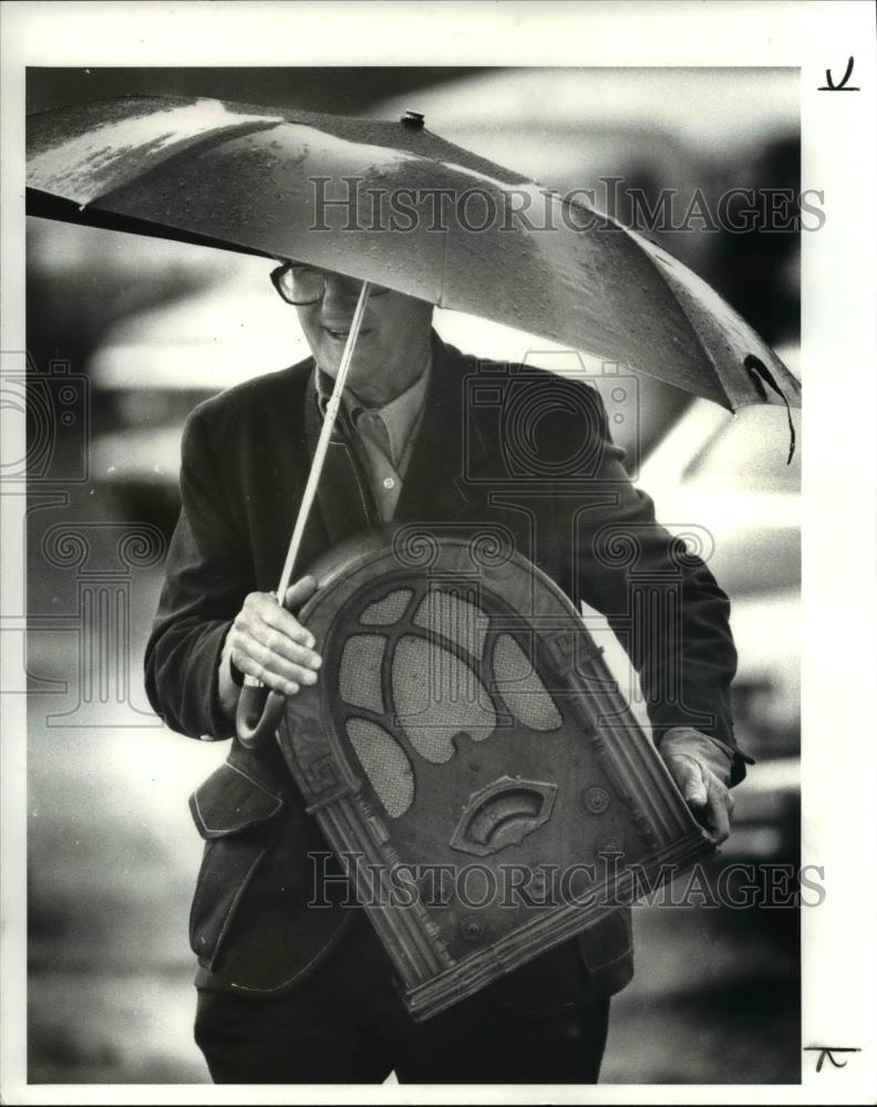 1982 Press Photo Man with Purchase in Rain at Great Geauga County Flea Market - Historic Images